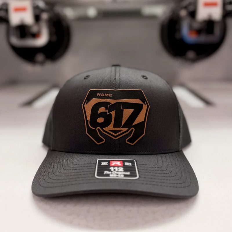 Black trucker hat with a tan Suzuki number plate patch