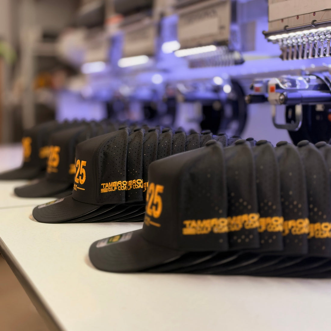 A run of black custom hats with gold embroidered numbers