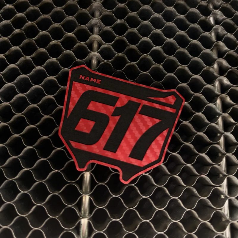 Red carbon fiber leatherette number plate patch on the laser bed